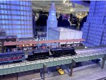 The model polar express train runs on the elevated structure with the model tall buildings in the background.